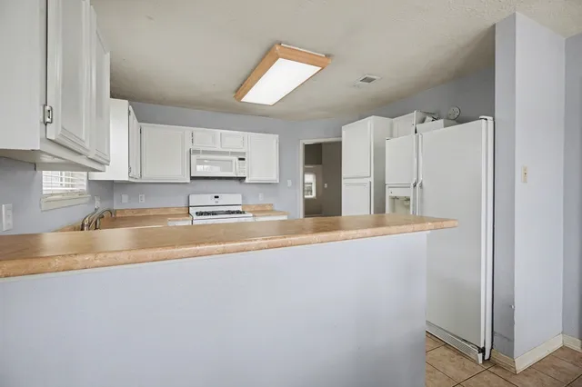 a view of kitchen with stainless steel appliances granite countertop a refrigerator and a sink