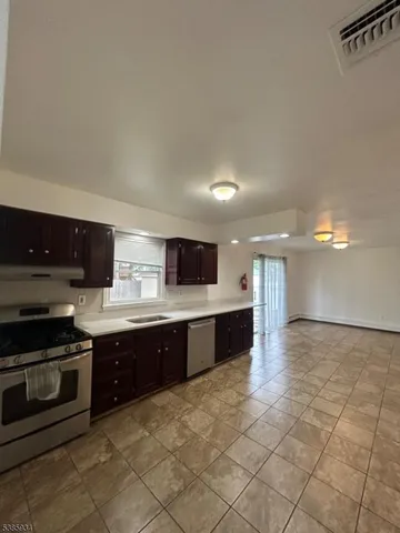 a large kitchen with stainless steel appliances granite countertop a sink and cabinets