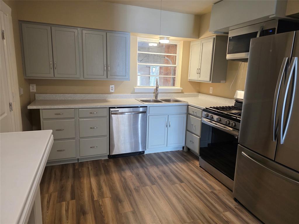 1513 Arcady Lane Irving, TX 75061 - Photo 4 of 20 a kitchen with stainless steel appliances a stove a sink and a refrigerator