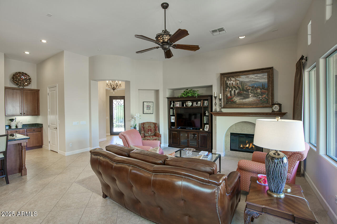 9190 East Hoverland Road Scottsdale, AZ 85255 - Photo 10 of 35 a living room with furniture a fireplace and a flat screen tv