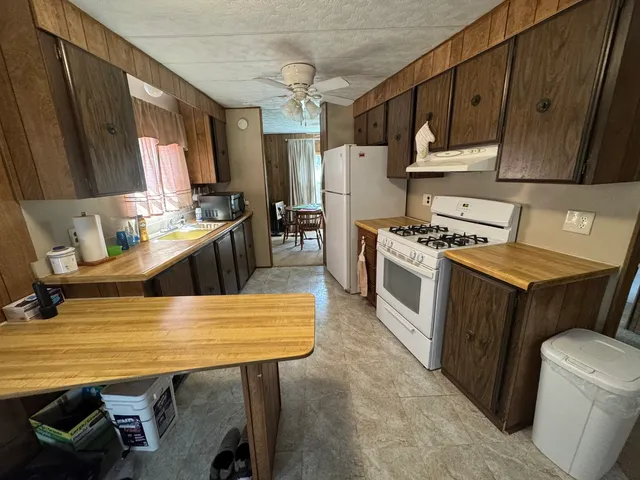 a kitchen with a table chairs stove and refrigerator