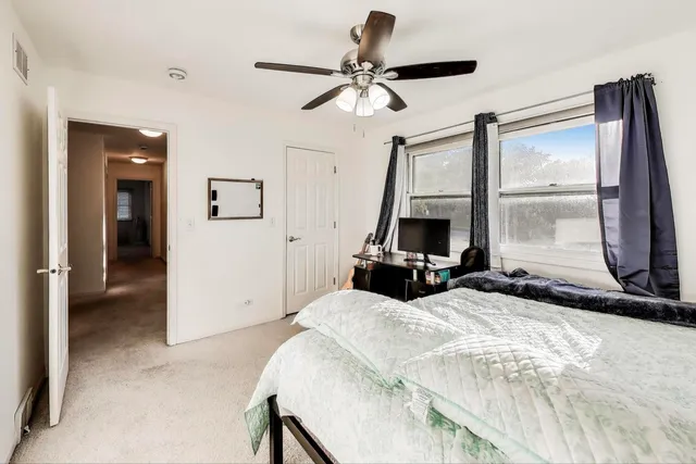 a bedroom with a bed and a large window