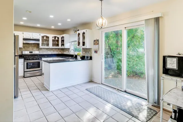 a kitchen with stainless steel appliances granite countertop a stove a sink and a refrigerator