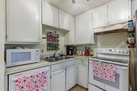 a kitchen with granite countertop cabinets stainless steel appliances and a counter space