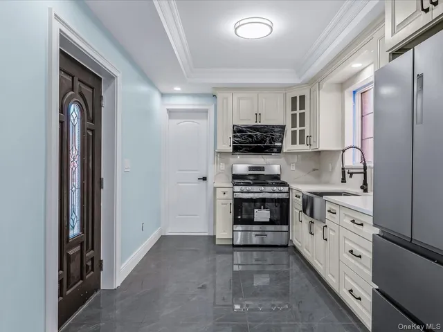 a kitchen with granite countertop white cabinets and refrigerator