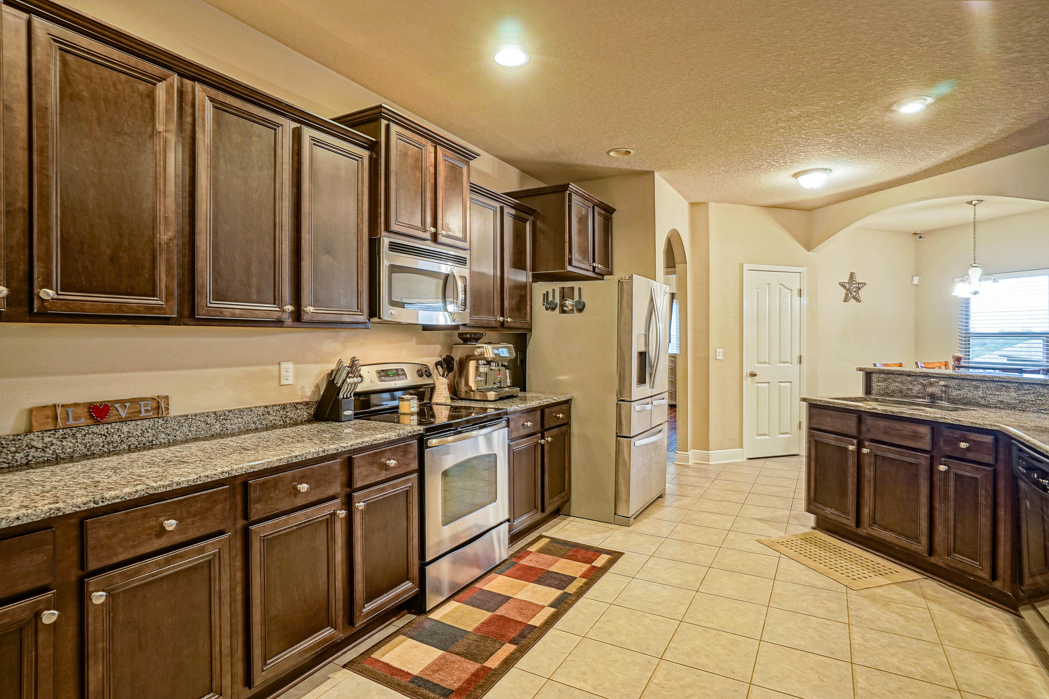 631 Red Fern Road Crestview, FL 32536 - Photo 4 of 23 a kitchen with stainless steel appliances granite countertop a stove a sink and a refrigerator