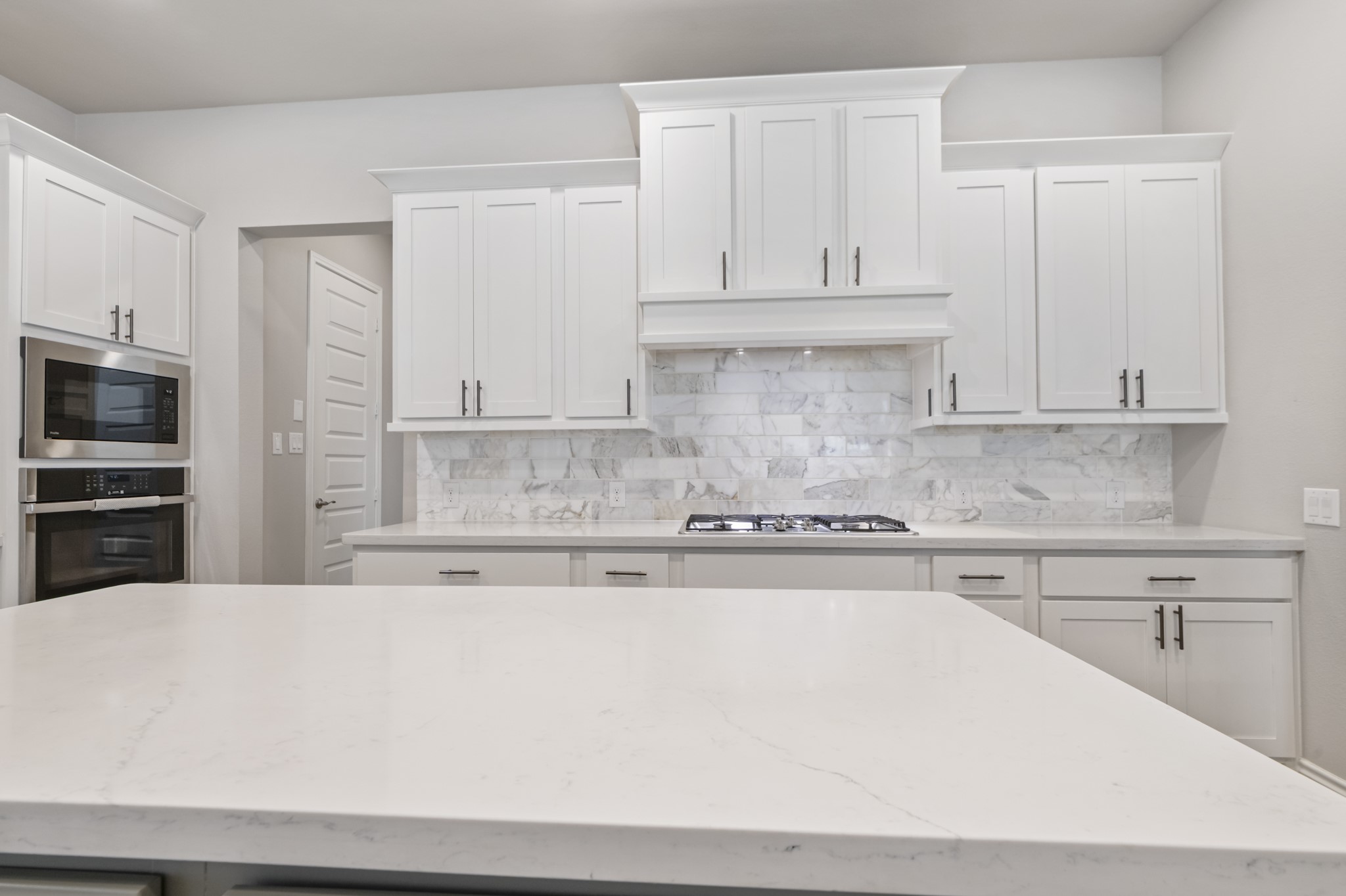 104 Catani Loop Georgetown, TX 78628 - Photo 25 of 34 This kitchen features white cabinetry, stainless steel appliances, a gas cooktop, and a light-colored countertop