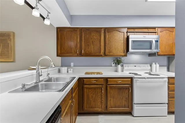 a kitchen with stainless steel appliances granite countertop a sink stove and microwave