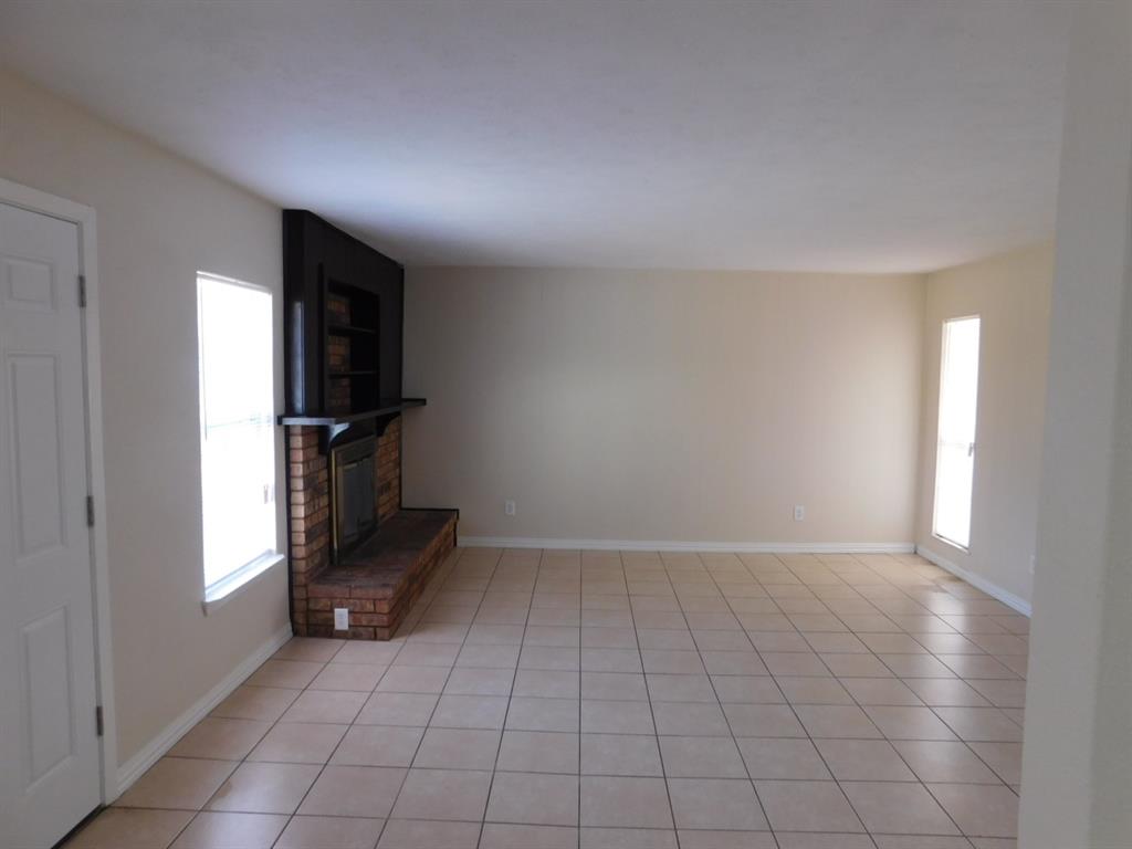 10371 White Elm Road Dallas, TX 75243 - Photo 6 of 11 Unfurnished living room with light tile patterned floors, plenty of natural light, and a fireplace