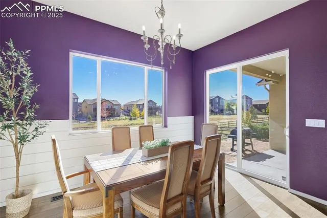a dining room with furniture a chandelier and wooden floor