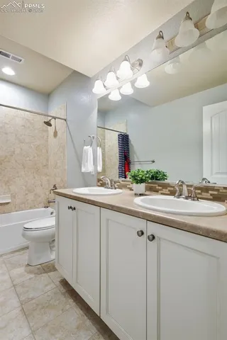 a bathroom with a granite countertop sink a toilet and a mirror