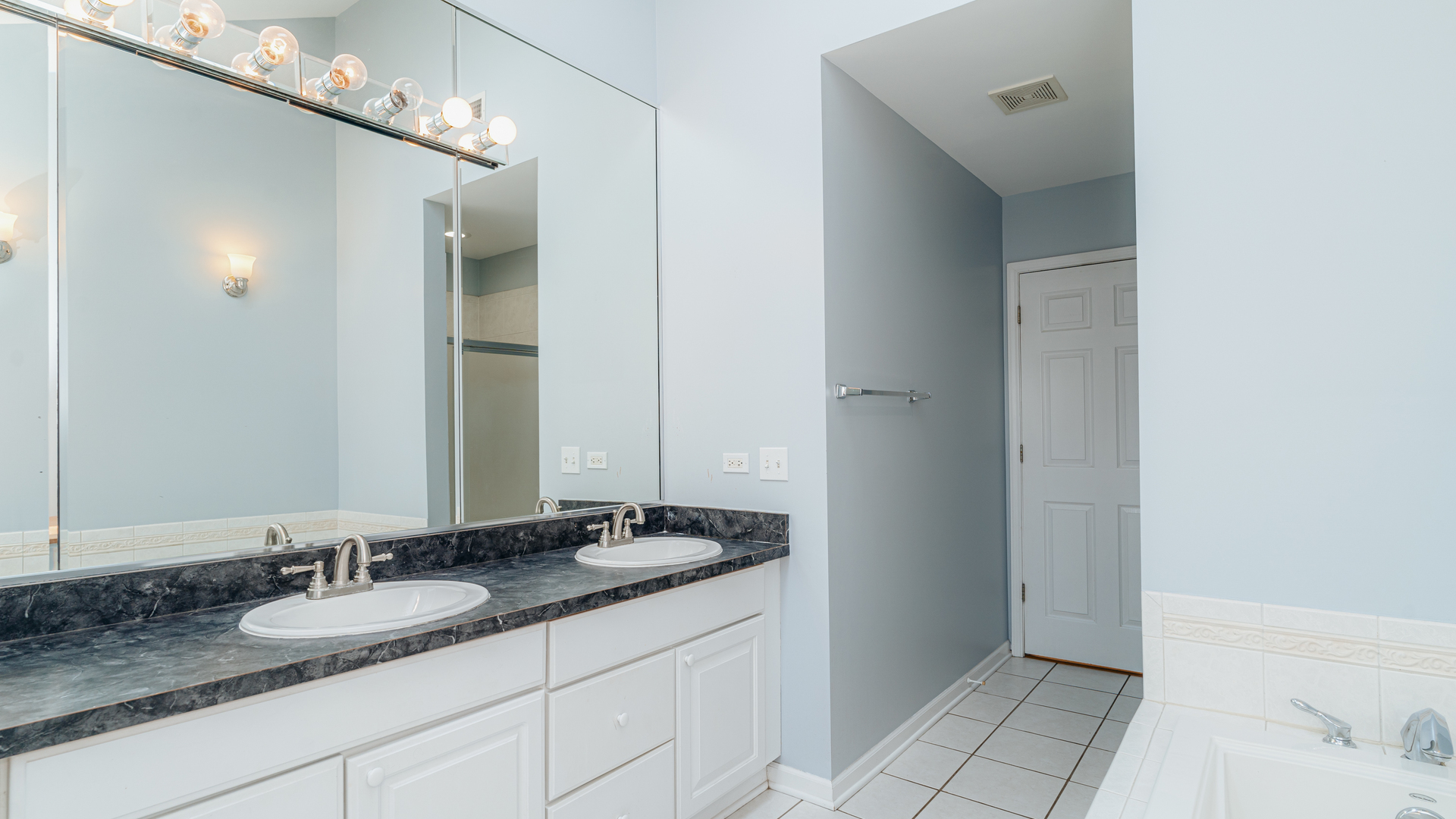 2319 West Harrison Street, Unit 4 Chicago, IL 60612 - Photo 18 of 25 a bathroom with a granite countertop sink and a mirror