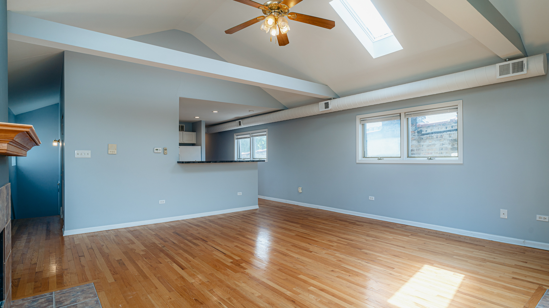 2319 West Harrison Street, Unit 4 Chicago, IL 60612 - Photo 6 of 25 a view of an empty room with wooden floor and a window