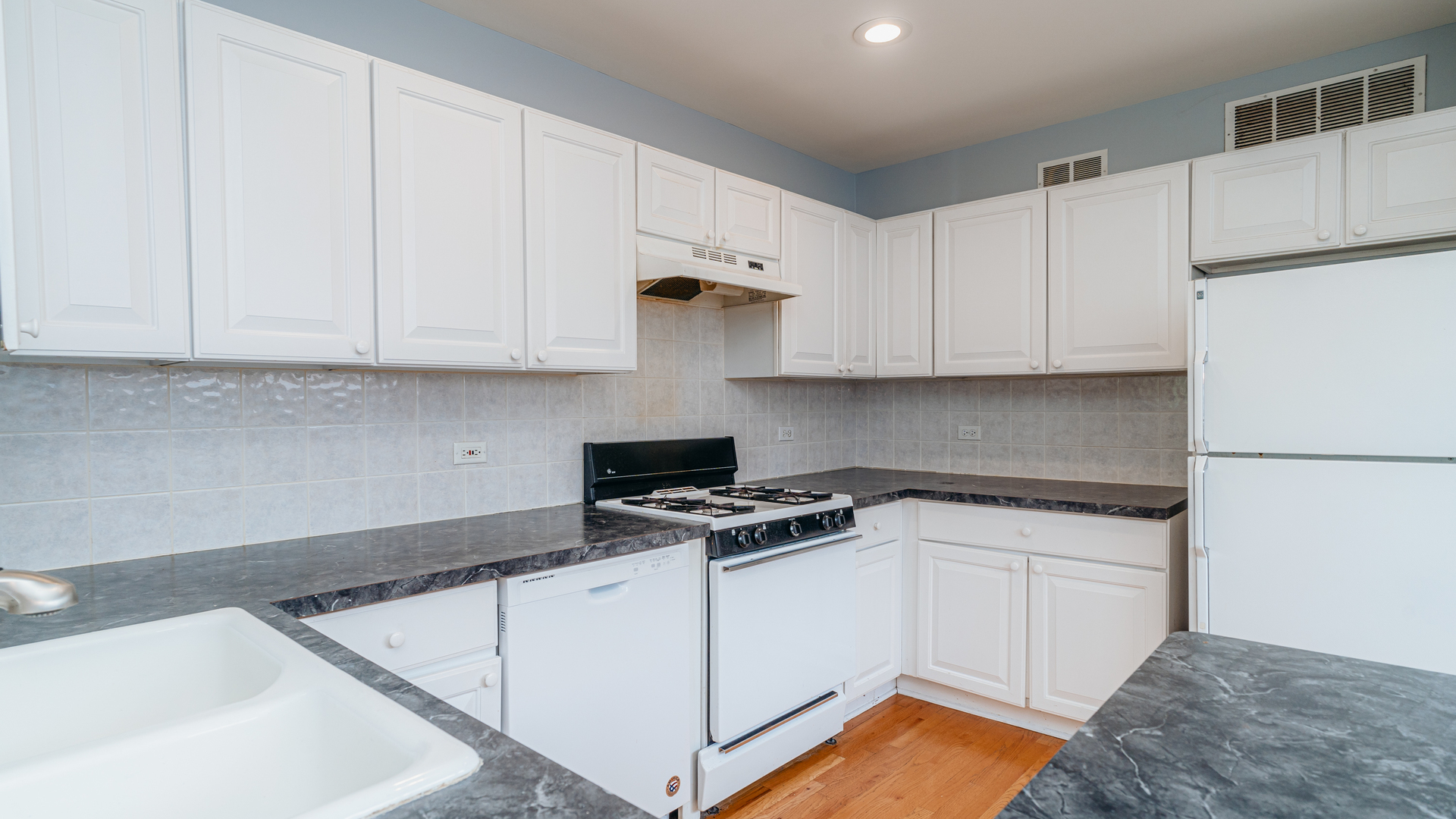 2319 West Harrison Street, Unit 4 Chicago, IL 60612 - Photo 9 of 25 a kitchen with white cabinets and white appliances