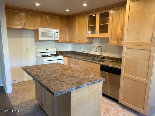 1724 Sinaloa Road, Unit 125 Simi Valley, CA 93065 - Photo 3 of 17 a kitchen with kitchen island granite countertop wooden cabinets and a refrigerator