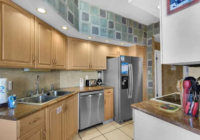 a kitchen with stainless steel appliances granite countertop a sink refrigerator and cabinets