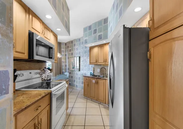 a kitchen with stainless steel appliances a refrigerator a stove top oven a sink and dishwasher
