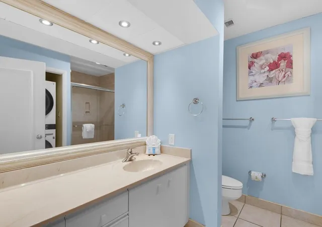 a bathroom with a sink a toilet and a large mirror