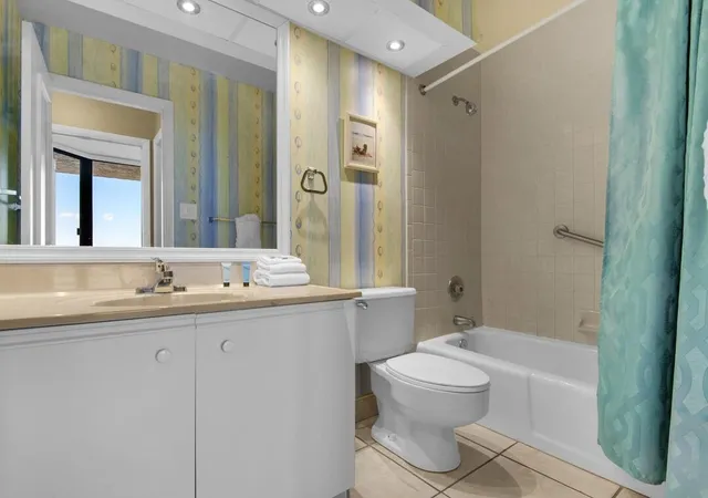 a bathroom with a toilet a sink a mirror a bathtub and vanity