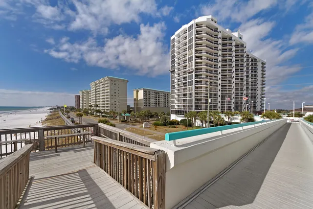 a view of balcony with a couple of cars parked in parking lot
