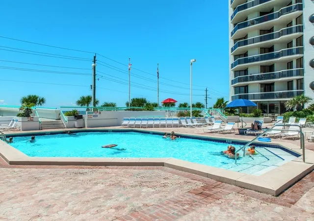 a view of a swimming pool with a patio and a lake view