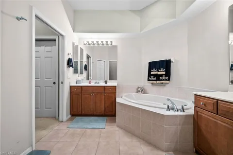 a spacious bathroom with a tub sink and mirror