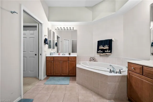 a spacious bathroom with a tub sink and mirror