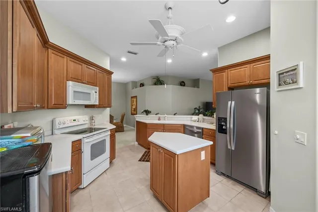 a kitchen with stainless steel appliances granite countertop a refrigerator a stove a sink and a microwave