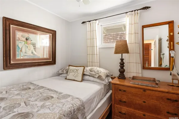 a bedroom with a bed and a lamp on dresser