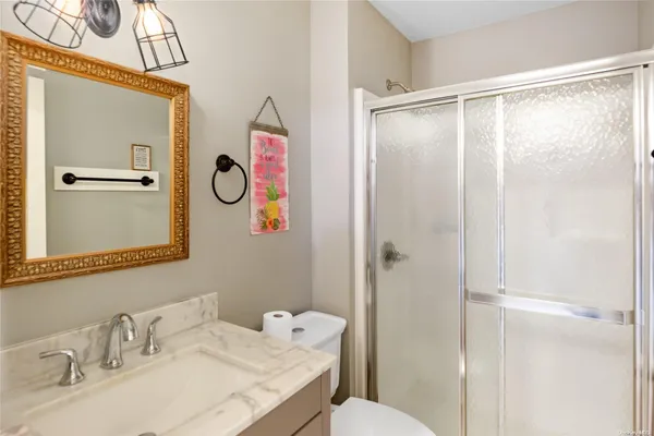 a bathroom with a granite countertop sink mirror and a shower