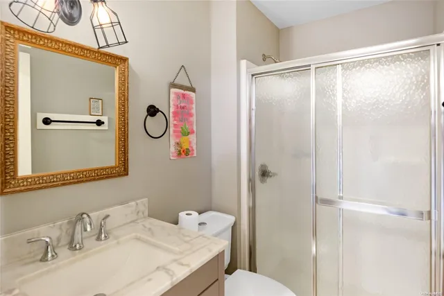 a bathroom with a granite countertop sink mirror and a shower