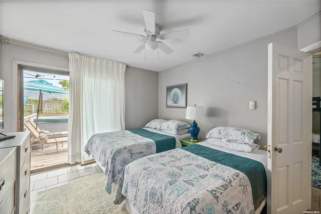 a bedroom with two beds and large windows