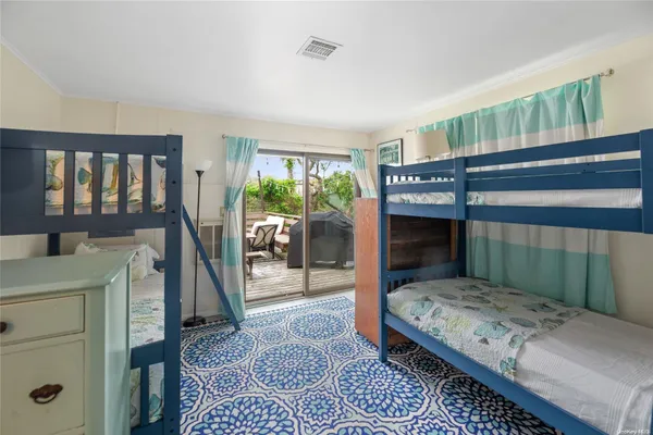 a bedroom with a bed a rug and a large window