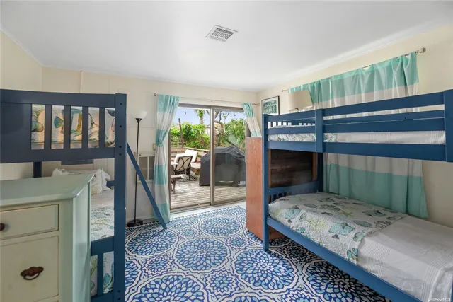 a bedroom with a bed a rug and a large window