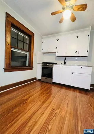 a kitchen with stainless steel appliances granite countertop a dishwasher a stove and a wooden floor