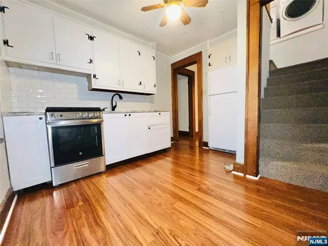 a kitchen with granite countertop a stove a sink and a refrigerator