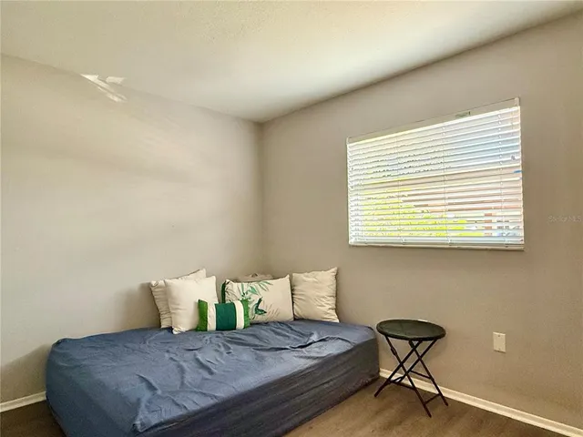 a bedroom with a bed and next to a window