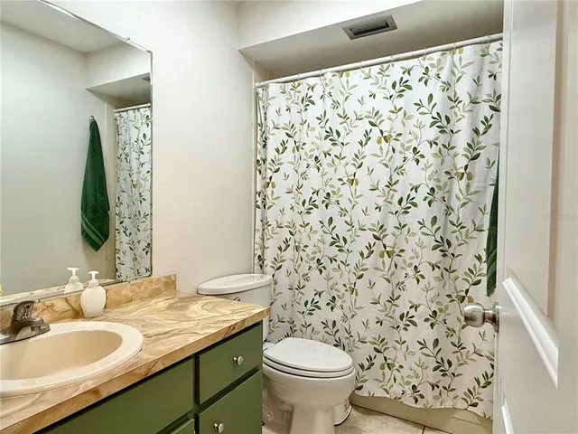 a bathroom with a granite countertop sink a toilet and a mirror