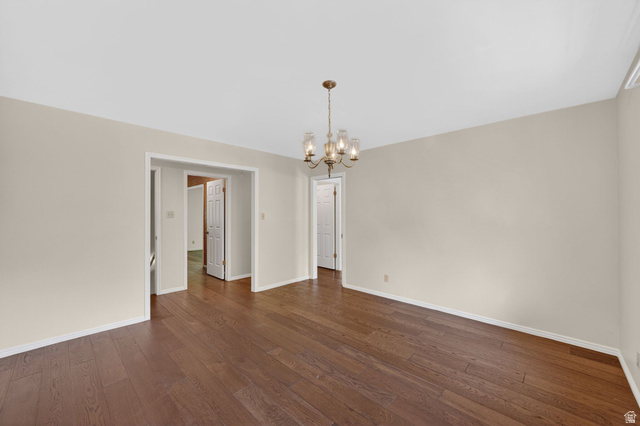 3120 North Apache Way Provo, UT 84604 - Photo 28 of 58 Spacious room featuring wood-finish flooring, a brass-toned chandelier with glass shades, neutral wall paint, and white trim throughout
