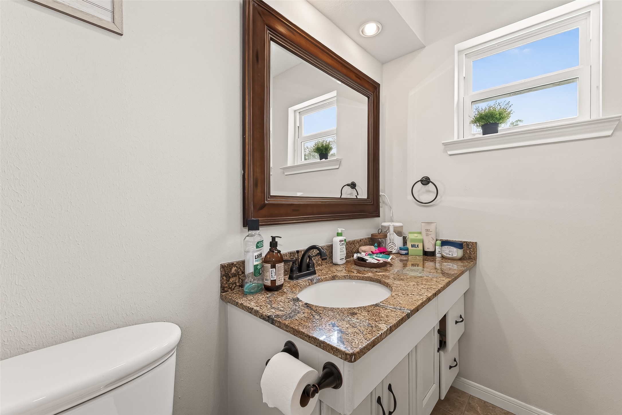 15843 Foxgate Road Houston, TX 77079 - Photo 35 of 49 a bathroom with a granite countertop sink a toilet and a mirror