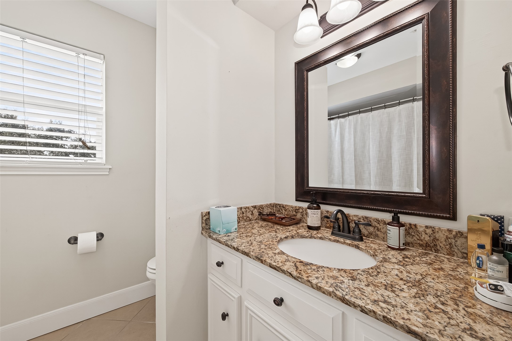 15843 Foxgate Road Houston, TX 77079 - Photo 36 of 49 a bathroom with a granite countertop sink and a mirror