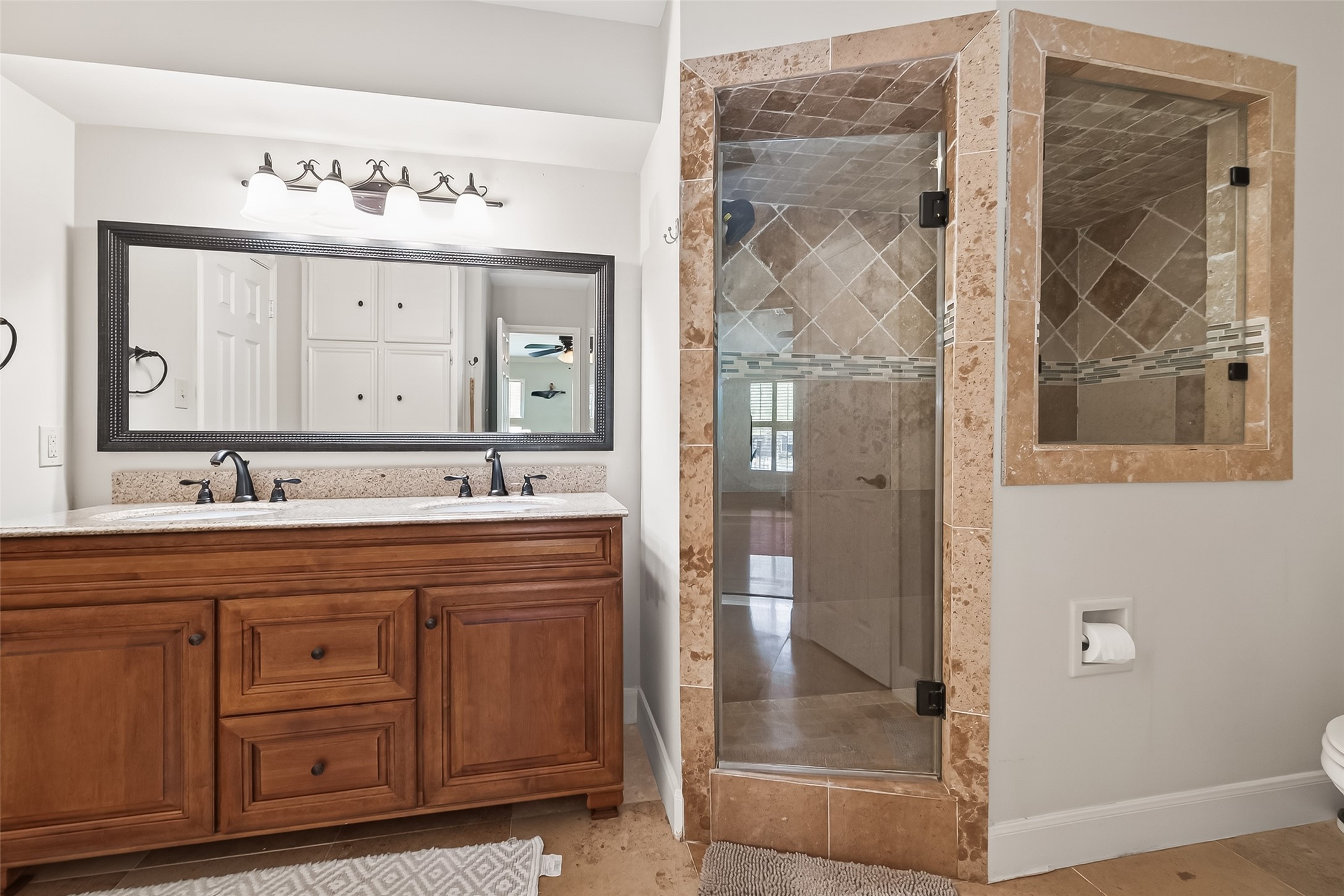 15843 Foxgate Road Houston, TX 77079 - Photo 45 of 49 a bathroom with a sink a mirror a glass door and shower