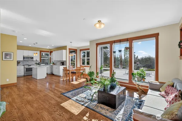 a living room with furniture floor to ceiling window and wooden floor