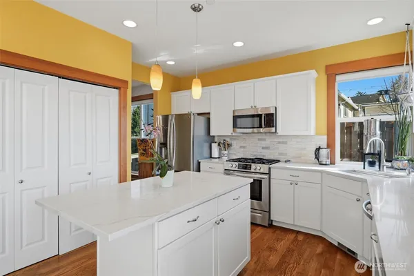 a kitchen with stainless steel appliances a sink a stove a refrigerator cabinets and a counter top space