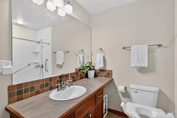 a bathroom with a granite countertop sink a toilet and a mirror