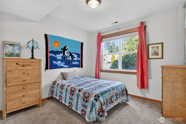 a bedroom with a bed a dresser and a window