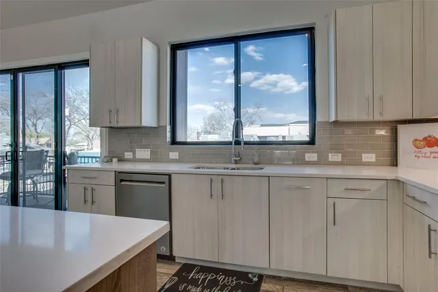 a kitchen with stainless steel appliances granite countertop a stove a sink and white cabinets