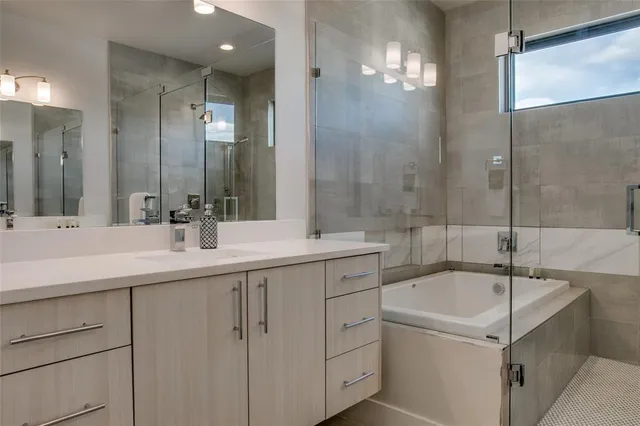 a bathroom with a bathtub a sink a mirror and a shower