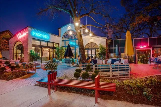a view of the patio with dining table and chairs under an umbrella