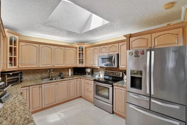 a kitchen with stainless steel appliances a refrigerator sink and cabinets